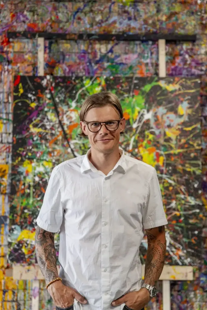Margus in front of a painted brick wall